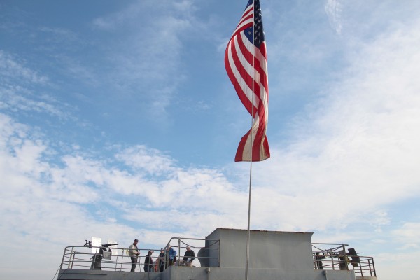 Veteran’s Day observers gather on an SS Red Oak Victory gun deck during the celebration at the Port of Richmond. (Photo by: Kevin N. Hume)